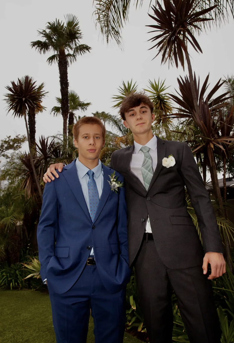 Eli R. '26 (left) and Kai B. '26 (right) pose together before prom in their suits